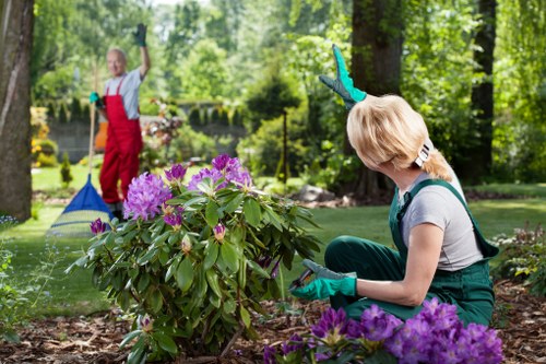 Gardener preparing hedge trimmers and PPE on site in a residential area